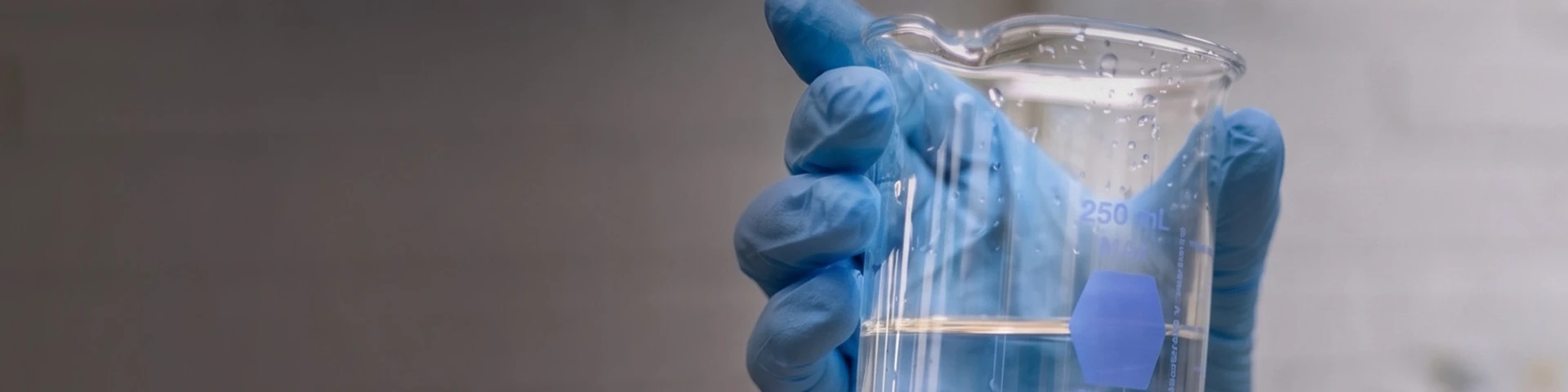 Water Softener salt dissolved in a beaker with a blue logo